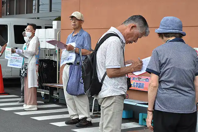 西奈良県民センター跡地の売却中止求める署名に応じる人（右から2人目）＝2023年7月8日、奈良市中山町西１丁目