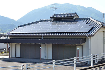 栗阪の集会所屋根に設置された太陽光発電装置。栗阪自治会には太陽光発電装置設置で2億円が交付されたが、事業完了には至っていない＝2016年5月12日、御所市栗阪