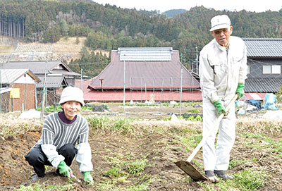 学校給食に野菜を提供する井上雅夫さん（右）夫婦。「おいしいと喜んでもらえることが励みになる」と学校給食センターの取り組みを歓迎している