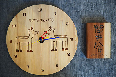 春日大社の杉を使った商品の開発から生まれた時計（左）と表札