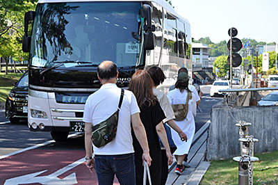 路肩を歩く通行者をよけるように走行する観光バス＝2019年5月4日、奈良市登大路町