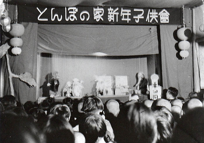 「トンボ座」の人形劇を見る子どもたち。動物たちの人形と操りの糸が見える＝1930年ごろ、堀田穣さん所蔵