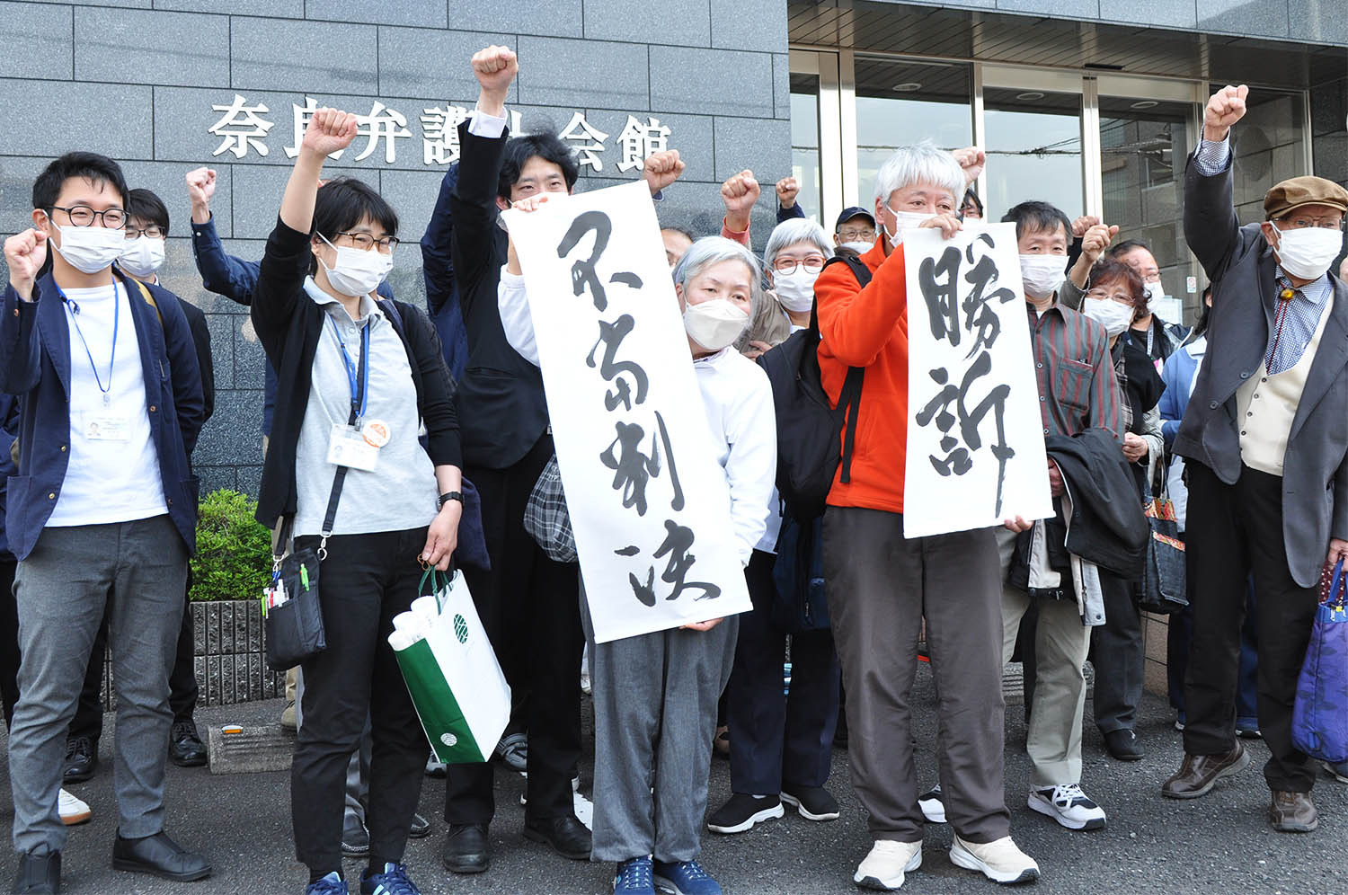 判決を受けて拳を上げる原告や支援者の人たち＝2023年4月11日、奈良市内