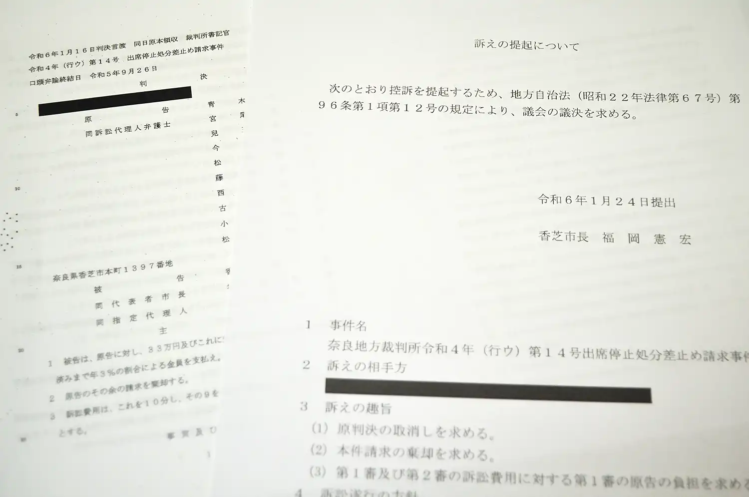 青木恒子議員の処分を巡る奈良地裁の判決文（左、弁護団提供）と控訴の承認を求める香芝市の議案書（右）
