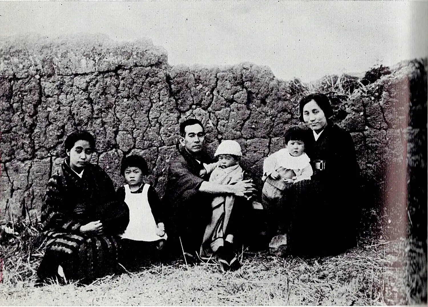 小川晴暘撮影、加納鉄哉旧居前の土塀の記念写真。右から志賀直哉の妹、實吉英子、その子、直哉の次男・直吉、直哉、直哉の四女・万亀子、網野菊